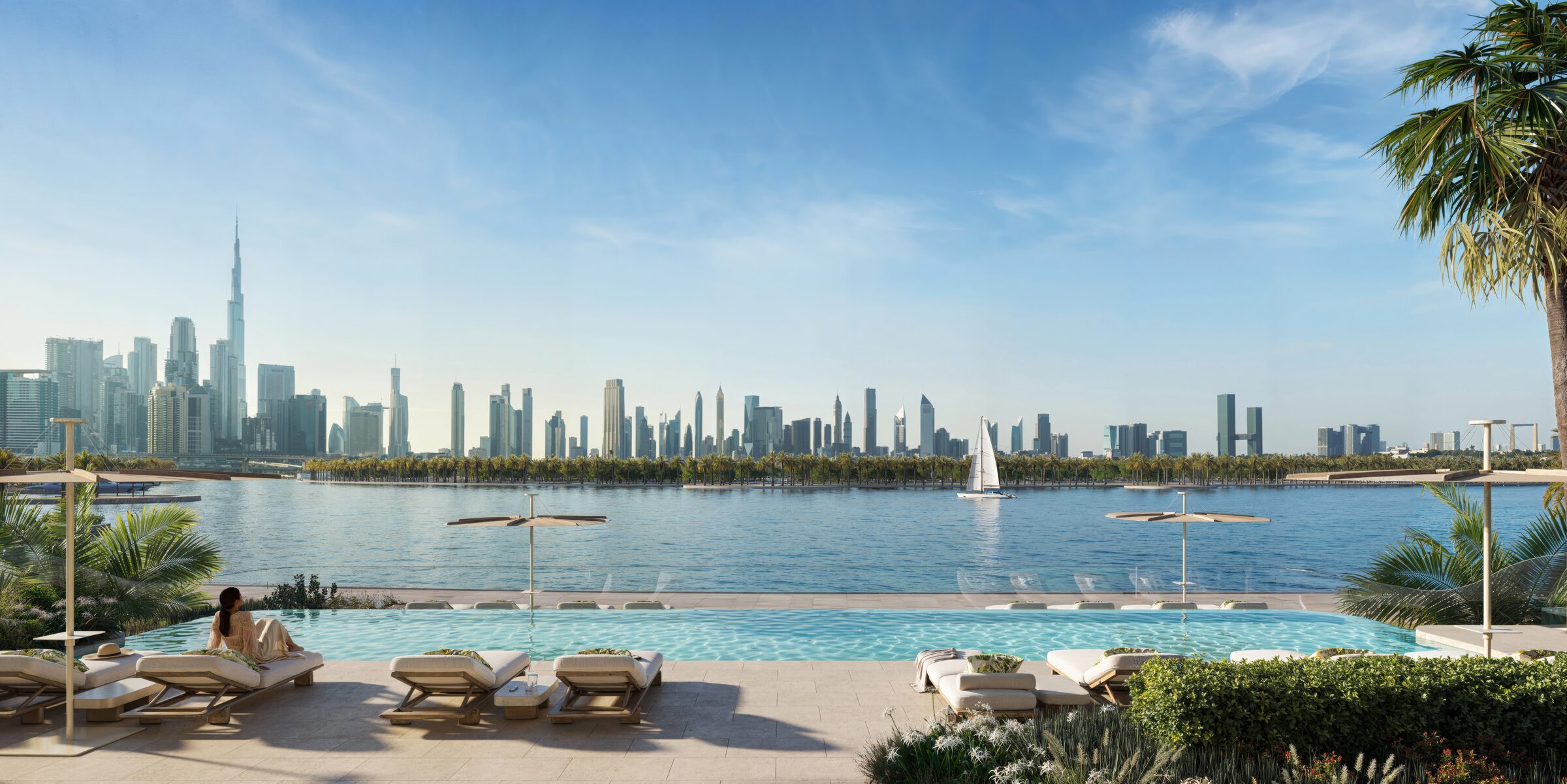 Waterfront pool deck at ground level with loungers facing the Downtown skyline across the water