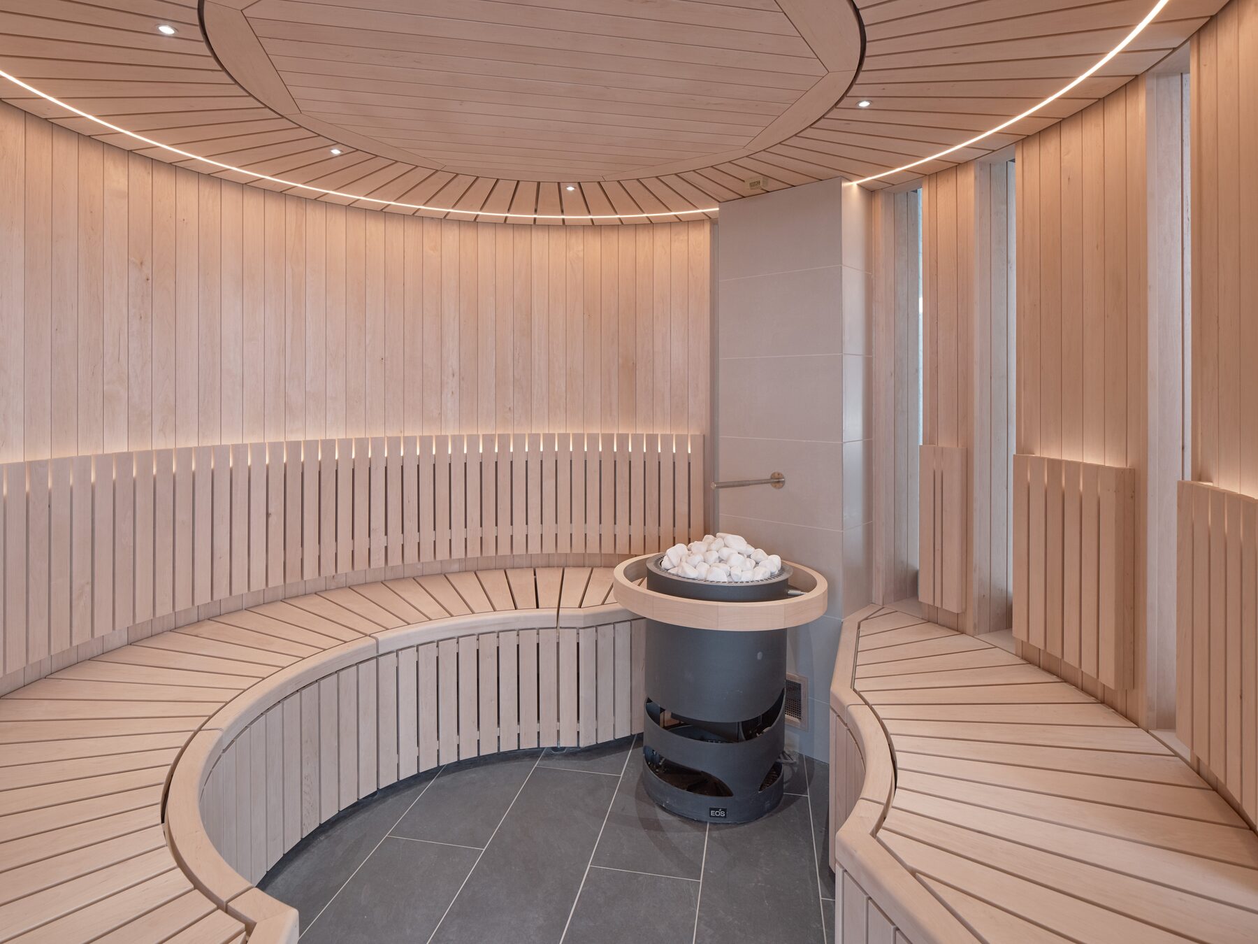 Circular timber sauna with central stone burner