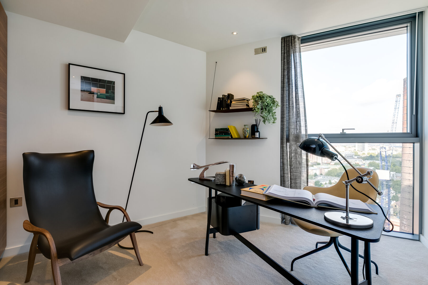Study with leather armchair and a chimney view through full-height glazing