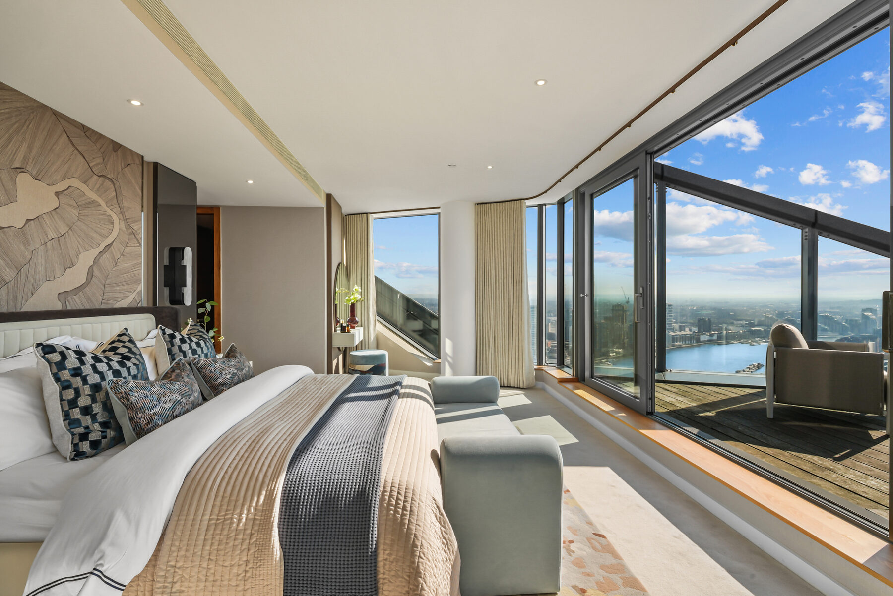 Penthouse bedroom with corner glazing over the river and the Palm-lined reach below